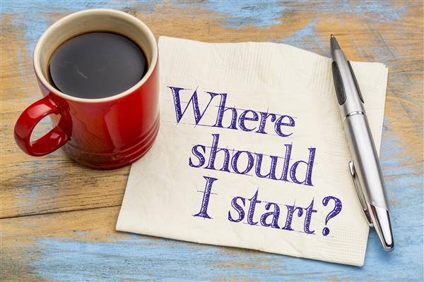 Red coffee cup and pen on paper which reads "Where Should I Start?" in purple text. 